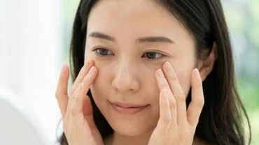 Người phụ nữ đang chạm nhẹ tay lên vùng khóe mắt thể hiện sự băn khoăn khi tìm hiểu mắt giật ở nữ là điềm gì