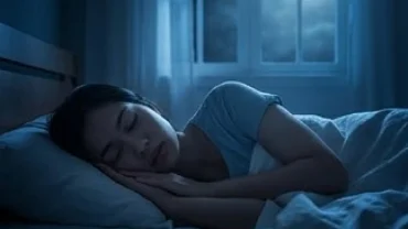 Người phụ nữ nằm ngủ trằn trọc trong bóng tối phản ánh trạng thái bất an khi mơ bị bắt cóc
