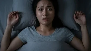 Người phụ nữ mồ hôi đầm đìa trằn trọc trên giường khi trải qua hiện tượng mơ bị bóng đè