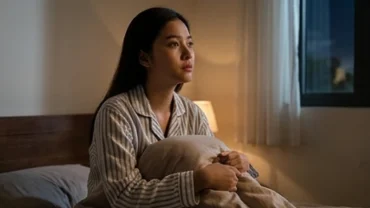 Trạng thái trằn trọc suy tư sau khi mơ thấy cãi nhau với mẹ trong không gian phòng ngủ tĩnh lặng