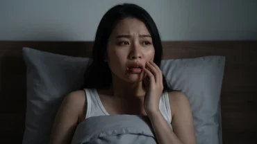 Khuôn mặt người phụ nữ lo âu khi tỉnh giấc sau khi mơ thấy chảy máu răng trong đêm