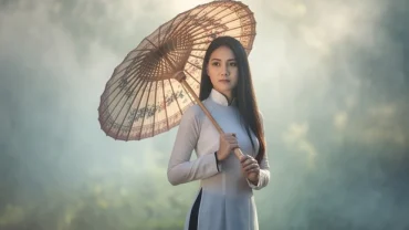 Người phụ nữ đứng dưới sương mù huyền ảo tượng trưng cho những điềm báo sâu xa khi mơ thấy che ô dù