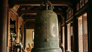 Quả đại hồng chung bằng đồng cổ kính dưới ánh nắng thanh tịnh, biểu tượng tâm linh cho người mơ thấy chuông chùa