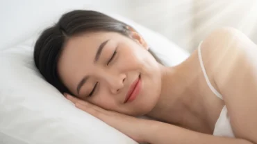 Người phụ nữ ngủ say với nụ cười thanh thản trên môi, tượng trưng cho điềm báo cát lành khi mơ thấy răng mới