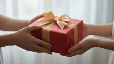 Người đang nâng niu và chủ động trao hộp quà bọc giấy đỏ khi mơ thấy tặng quà cho người khác