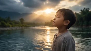 Bé nhỏ bình an tỉnh lại bên bờ nước trong xanh, thể hiện ý nghĩa tích cực của việc mơ thấy trẻ con chết đuối sống lại
