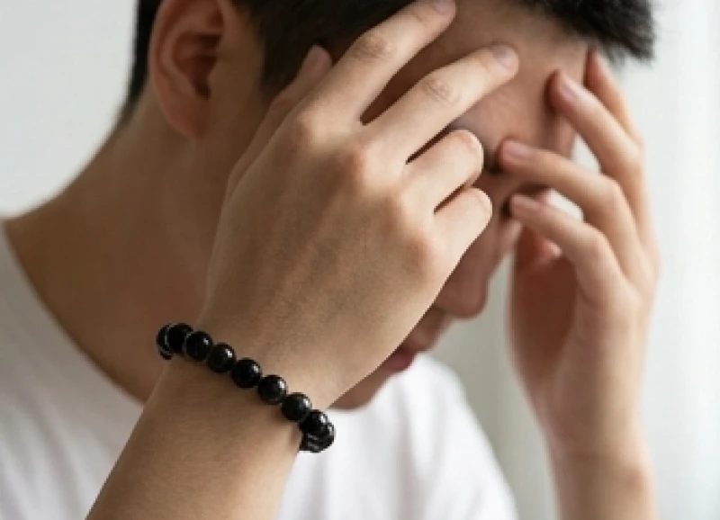 Tuổi Tuất hợp đá gì: Tra cứu 5 nạp âm và tỷ lệ thanh tẩy 10 Người đeo vòng đá phong thủy xoa nhẹ thái dương thể hiện sự mệt mỏi do từ trường tương khắc gây ra