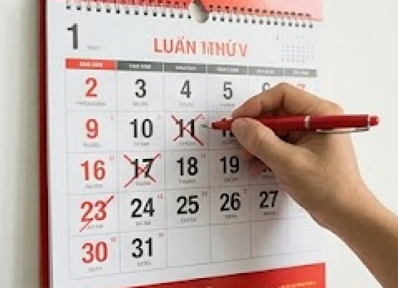 Tuổi Thìn mua xe ngày nào tốt: Bảng tra cứu 12 tháng 3 Người đàn ông đang cẩn thận dùng bút đỏ gạch chéo những ngày xấu trên tờ lịch treo tường