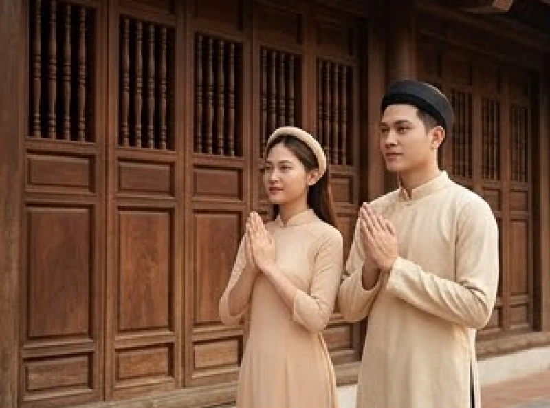 Văn khấn cầu con chuẩn nghi lễ: Cách sắm lễ và chọn ngày lành 1 Hai vợ chồng mặc trang phục lịch sự chắp tay cầu nguyện thành kính tại đền chùa