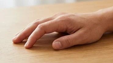 Bàn tay có ngón trỏ cong bất thường đang được kiểm tra cẩn thận dưới ánh sáng tự nhiên