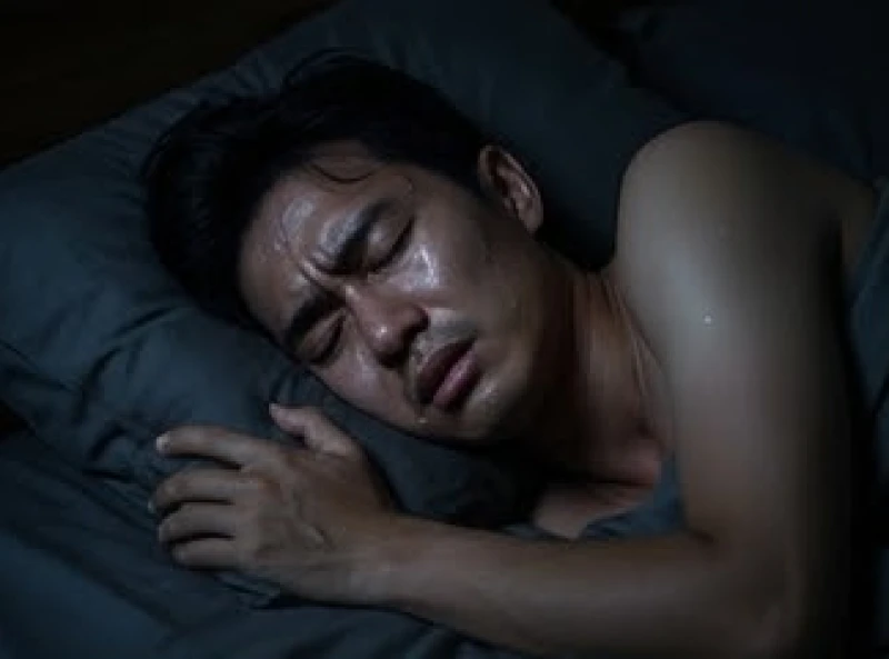 Gương mặt mệt mỏi và đổ mồ hôi của một người đang nhíu mày chìm trong giấc ngủ mộng mị căng thẳng