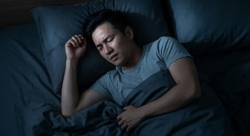 Người đàn ông khó ngủ và trằn trọc trên giường do mức cortisol tăng cao vào ban đêm