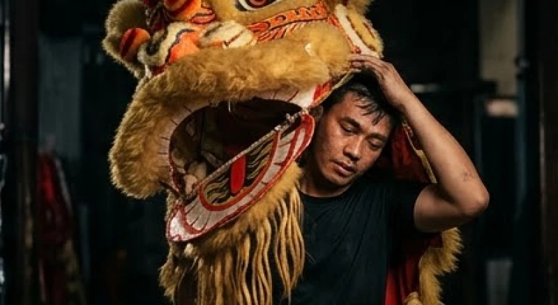 Mơ thấy múa lân: Điềm báo, số tài lộc và cách hóa giải 4 Nghệ sĩ múa lân đang ngồi nghỉ ngơi bên cạnh chiếc đầu lân bằng giấy bồi sau một màn trình diễn tốn nhiều sức lực