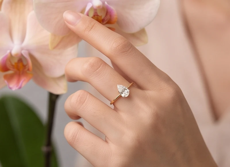 Chiếc nhẫn nữ đai mảnh với mặt đá hình giọt nước tôn lên vẻ thanh lịch và mềm mại của đôi bàn tay