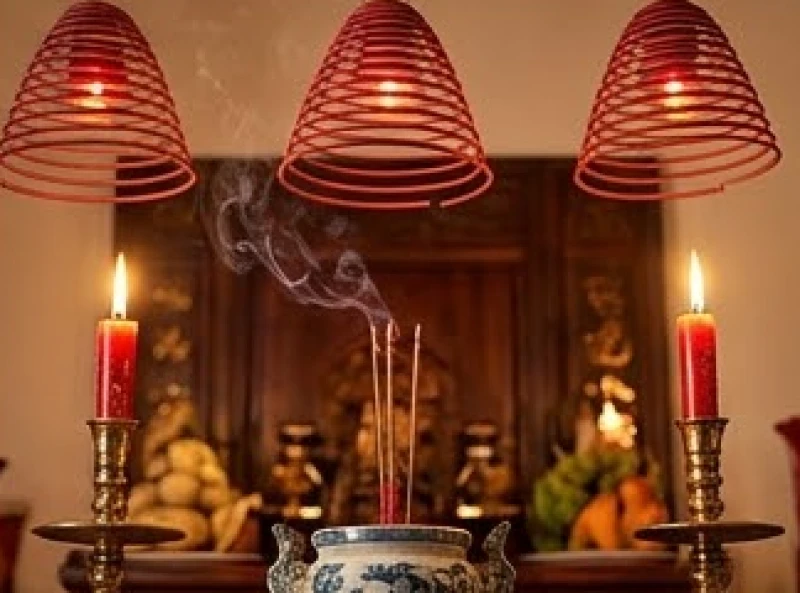 Nhang vòng cháy đỏ và nến thắp sáng trên ban thờ tổ tiên ngày Tết