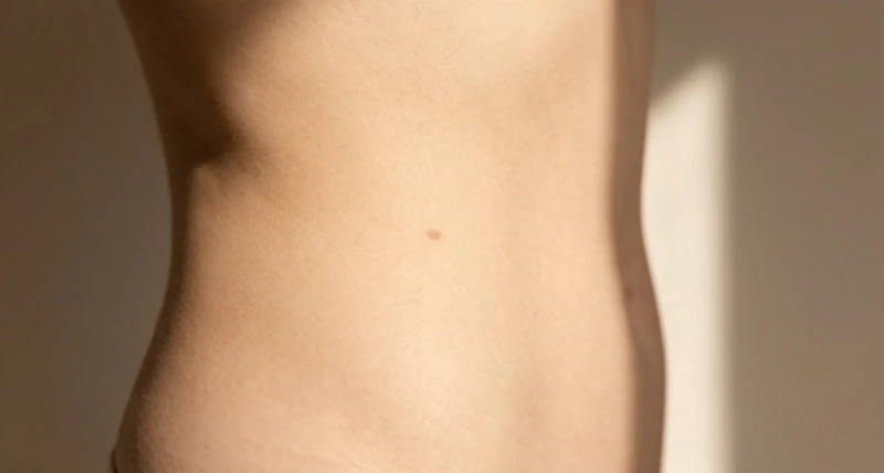 Cận cảnh một nốt ruồi chìm màu nhạt nằm lẩn khuất dưới lớp da vùng sườn eo