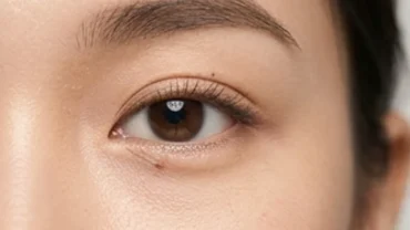Cận cảnh khuôn mặt thanh tú với nốt ruồi lệ bên phải dưới mắt rõ nét