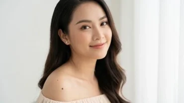 Phụ nữ có nốt ruồi ở vai trái đang mặc áo trễ vai thanh lịch và tự tin khoe dáng