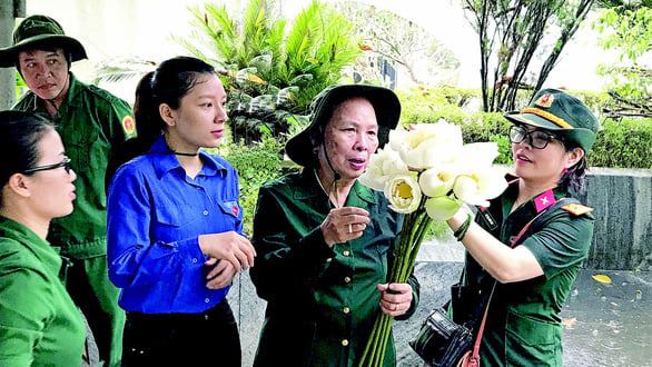 Bà Nguyễn Thị Hường (o Hường) - người 50 năm qua lưu giữ những trang lưu bút của 10 thanh niên xung phong hi sinh ở Đồng Lộc - đi viếng đồng đội. Ảnh Hoài Duy