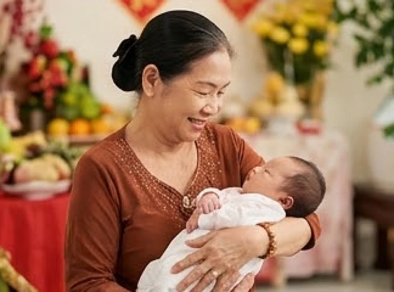 Bà nội vui vẻ bế cháu đích tôn trong lễ đầy tháng để mượn tuổi truyền năng lượng an lành