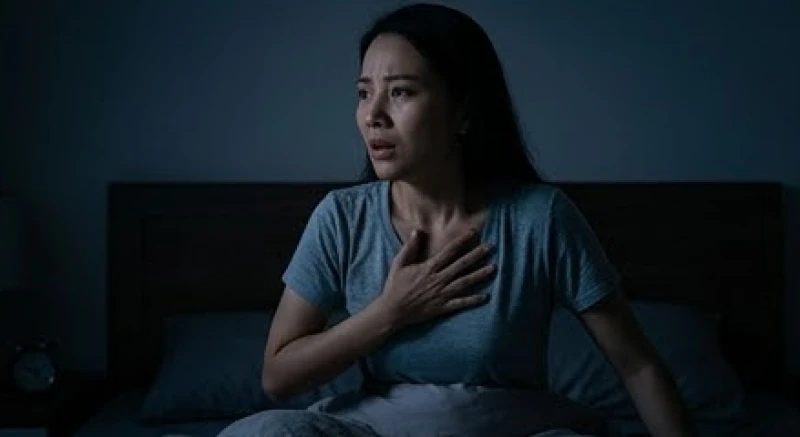 Một người phụ nữ giật mình tỉnh giấc giữa đêm, nhịp tim đập nhanh và thở gấp do hội chứng kiệt quệ tâm lý