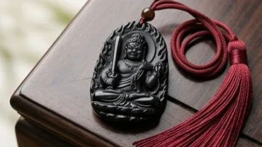 Mặt Phật bản mệnh tuổi Dậu Bất Động Minh Vương chạm khắc tinh xảo trên khối đá obsidian đen tự nhiên