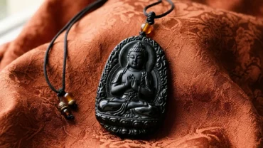 Mặt dây chuyền phật bản mệnh tuổi thân chạm khắc tinh xảo từ đá tự nhiên nguyên khối đặt trên nền lụa Á Đông