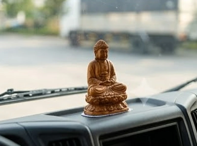 Tượng Phật nhỏ được dán cố định an toàn trên taplo xe tải kinh doanh để cầu bình an