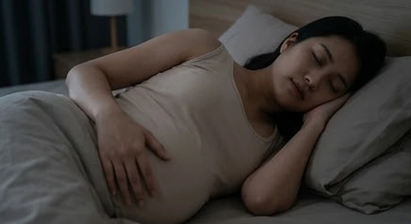Người phụ nữ mang thai đang nằm ngủ yên tĩnh trên giường trong căn phòng mờ tối