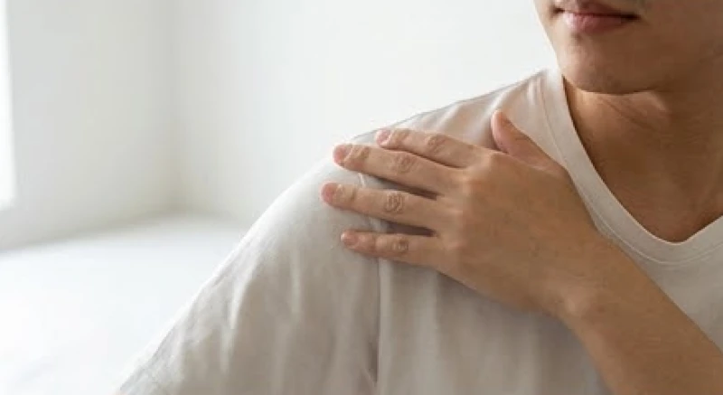 Thằn lằn ị lên người là điềm gì: Ý nghĩa vị trí & cách giải xui 5 Người đàn ông dùng tay phủi sạch vết bẩn dính trên vai áo trong không gian làm việc