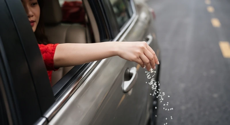 Đám cưới gặp đám ma là điềm gì: Cách nhường đường & hóa giải 4 Bàn tay nhẹ nhàng thả những hạt muối và gạo trắng qua khe cửa sổ xe ô tô xuống mặt đường nhựa