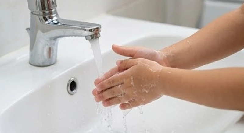 Trẻ em được hướng dẫn rửa sạch tay dưới vòi nước chảy để trôi đi dịch hóa chất