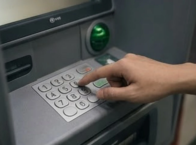Bàn tay thao tác dứt khoát trên bàn phím máy ATM để giải quyết các nhu cầu tài chính khẩn cấp