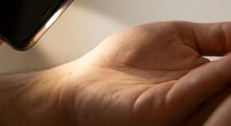 Sử dụng đèn pin điện thoại chiếu nghiêng để nhìn rõ các đường chỉ tay bị chìm