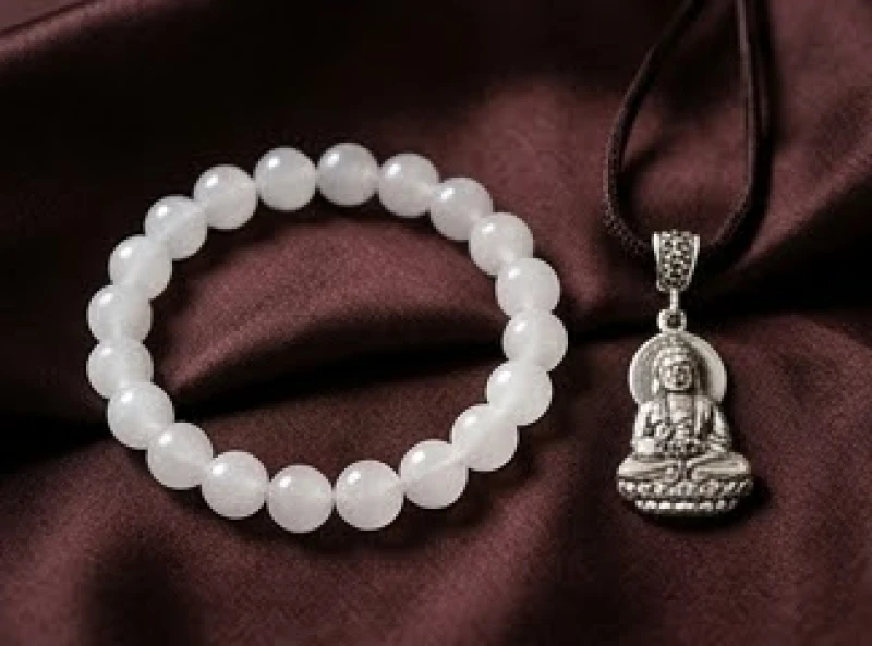 Vòng tay đá thạch anh trắng tinh khiết đặt cạnh mặt dây chuyền Phật bản mệnh bằng bạc