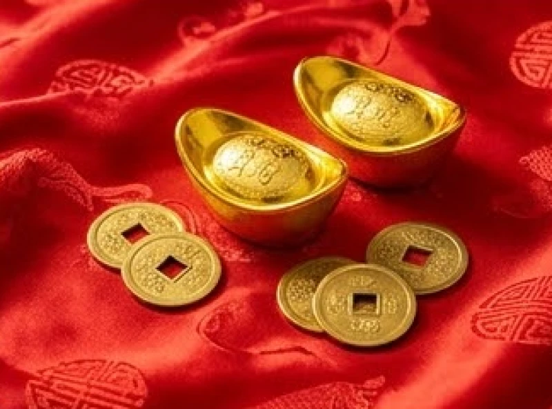 Những thỏi vàng tài lộc sáng bóng đặt cạnh nhau trên dải lụa đỏ tượng trưng cho sự dồi dào sinh khí trong các tháng Tam Hợp