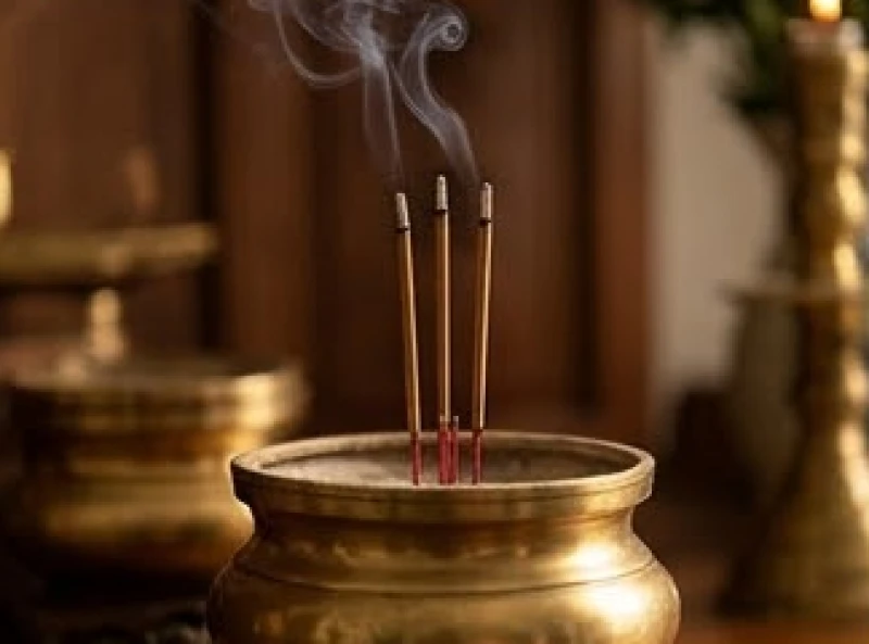 Ba nén nhang đang cháy dở đượm khói mờ ảo trên lư hương bằng đồng