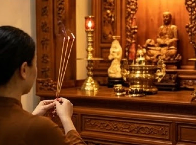 Gia chủ chắp tay thắp nhang trang nghiêm trước ban thờ gia tiên và thần linh