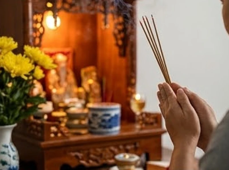 Văn khấn giỗ đầu mẹ: Bài cúng chuẩn nghi thức tại nhà & ngoài mộ 6 Người con chắp tay thắp hương thành kính trước bàn thờ Thổ Công và Thần Linh chúa đất