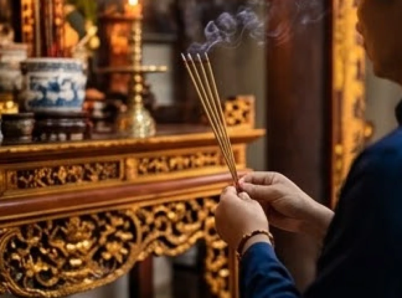 Văn khấn lễ hội Đền Và: Bài cúng chuẩn & quy trình đi lễ 6 Người đi lễ thành tâm chắp tay thắp nhang và dâng lễ vật tại ban thờ uy nghiêm bên trong không gian đền cổ kính