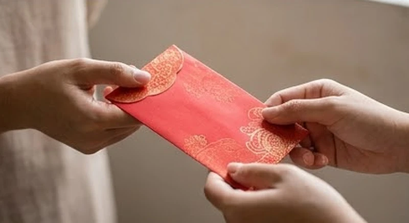 Đôi bàn tay nâng niu chiếc bao lộc màu đỏ thỉnh từ miếu Bà mang về nhà