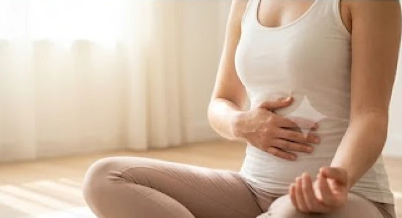 Một người thực hành bài tập hít thở sâu với bàn tay đặt nhẹ lên bụng để nạp lại năng lượng sống