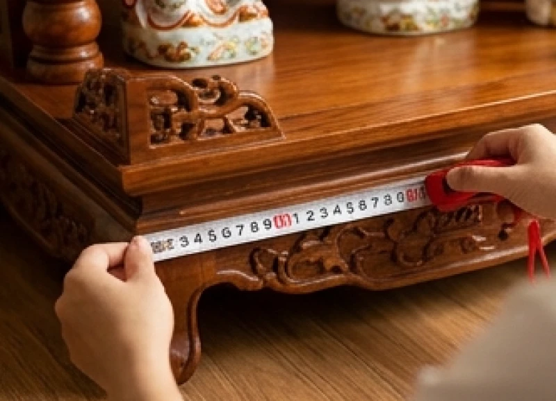 Đo kích thước mặt đáy tủ thờ bằng thước kéo Lỗ Ban để căn chỉnh vào cung Tài Vượng