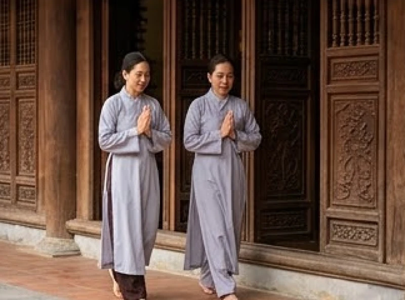 Văn khấn Vu Lan tại chùa: Trình tự hành lễ và bài cúng chuẩn 9 Nhóm Phật tử trong trang phục áo lam truyền thống bước đi nhẹ nhàng qua bậu cửa vào chính điện
