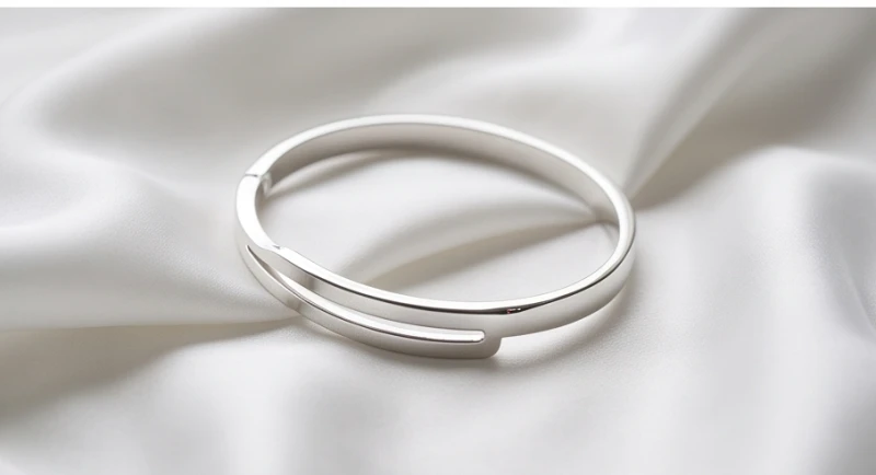 Chiếc vòng tay bằng bạc sáng bóng được đặt cẩn thận trên nền lụa trắng mang năng lượng hành Kim