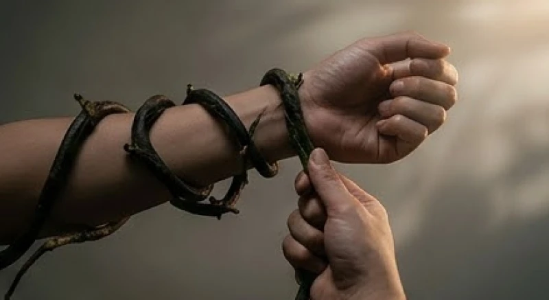 Mơ bị đỉa cắn là điềm gì: Giải mã tâm lý và cách hóa giải 4 Bàn tay mạnh mẽ gỡ bỏ một sợi dây đen đang trói buộc cổ tay tượng trưng cho việc thoát khỏi khủng hoảng