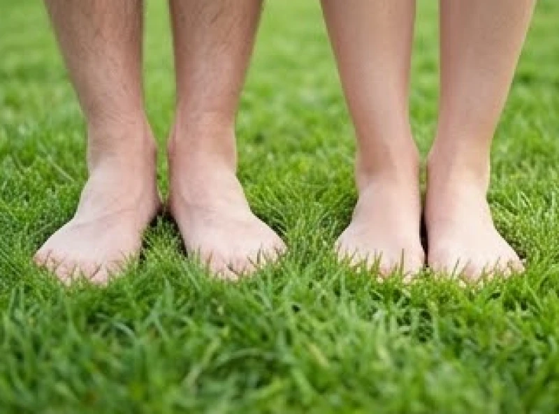 Tướng ngón chân cái ngắn: Ý nghĩa vận mệnh & cách hóa giải 3 Hai đôi bàn chân nam và nữ đứng cạnh nhau trên bãi cỏ xanh ngát