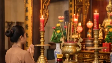 Người đi lễ chắp tay thành kính dâng hương và đọc văn khấn Đền Thượng Lào Cai trước ban thờ uy nghi