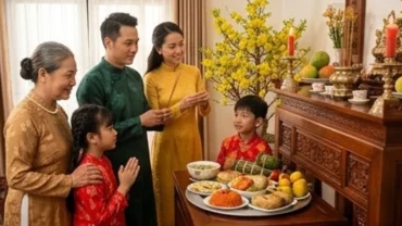 Gia chủ mặc áo dài truyền thống dâng hương và đọc văn khấn gia tiên mùng 1 Tết trước ban thờ ấm cúng