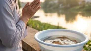 Người chắp tay thành kính đọc văn khấn phóng sinh bên chậu cá chép trước khi thả về tự nhiên